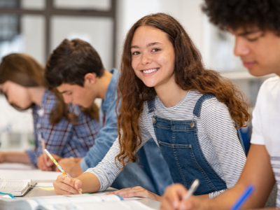 A student sitting and smiling