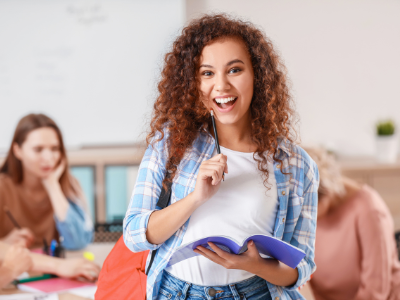 A student standing smiling in the classroom